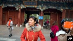 游人在北京大学入口拍照留念(2014年11月20日资料照)