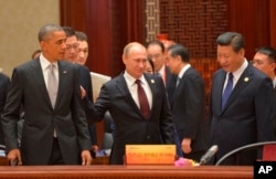 ( 前排坐起)美国总统奥巴马、俄罗斯总统普京和中国主席习近平在北京的亚太经合组织峰会上(2014年11月11日)