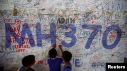 孩子们在吉隆坡国际机场的马航MH370航班的平安祝福墙上写下自己的祝愿。(2014年6月14日)