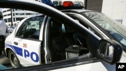 资料图——2005年9月11日,一名新奥尔良警察靠在一辆巡逻车上。