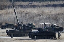 美军士兵在韩国举行的一次军演中站在M109A6(Paladin)帕拉丁型自走炮旁。(2016年3月10日)
