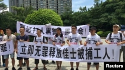 2018年8月6日,人们在中国广东省深圳市坪山区燕子岭派出所外示威,手持标语,支持佳士工厂工人。