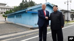 时任美国总统特朗普在韩国非军事区的板门店停战村和朝鲜领导人金正恩握手。(美联社:2019年6月30日)