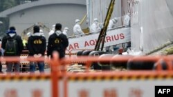 台湾中央流行疫情指挥中心工作人员身穿防护服登上基隆港的宝瓶星号游轮。(2020年2月8日)