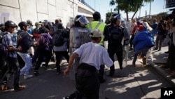 在蒂华纳市的过境点附近,移民们冲破一道警察防线,冲向美墨边境(2018年11月25日)