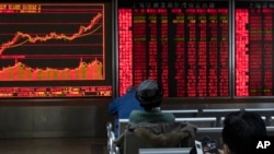 美中签署经贸协议后,投资者2020年1月16日在北京一家证券交易所观看行情,当天股市交易温和,涨跌互见。