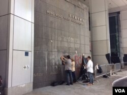2019年6月22日工人正在清理香港学界在警察总部外抗争集会现场 (美国之音记者申华拍摄)