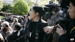 2006年4月20日,《大纪元》记者、法轮功修炼者王文怡在中国国家主席胡锦涛与布什总统在白宫南草坪会晤仪式上,从摄影人员站台上大声喊话。