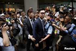 香港民族党召集人陈浩天在香港外国记者会演讲后离开时被媒体记者包围。 (2018年8月14日)
