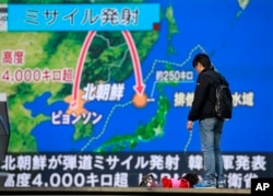 在日本东京,有人观看朝鲜发射洲际弹道导弹的电视新闻(2017年11月29日)。