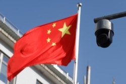 北京街头飘扬的一面中国国旗旁的一个监控摄像头。(2021年11月25日)