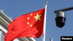 北京街头飘扬的一面中国国旗旁的一个监控摄像头。(2021年11月25日)