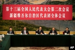 2019年3月12日在北京人民大会堂举行的全国人大会议新疆维吾尔自治区代表团会议上,新疆党委书记陈全国(中)讲话。讲台上的人前面都没有名牌。