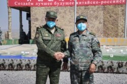 在中俄军队举行2021年联合军演期间,俄罗斯国防部长绍伊古抵达中国宁夏青铜峡与中国国防部长魏凤和(右)见面。(2021年8月13日)