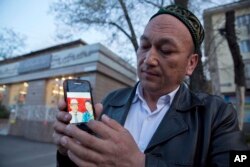 2018年3月31日,Omir Bekali在哈萨克斯坦阿拉木图拿着手机,上面显示了他父母的照片,他认为父母在中国被拘留。