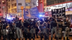 香港防暴警察在圣诞日向示威者展开警示将要采取镇压行动的旗子。(2019年12月25日)
