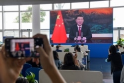 采访博鳌论坛的记者们在媒体厅观看屏幕上显示的中国国家主席习近平在开幕式上讲话的视频。(2021年4月20日)