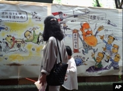 1996年3月23日,台北一个市场上的漫画。左侧漫画上有江泽民。右侧漫画上,台湾总统李登辉(右)安抚他的竞争对手说,他有18套办法对付中国导弹。