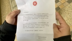 港府向每户逸葵楼居民派发信件,感谢居民配合7日围封强制检测行动,凭信件可以领取海味福袋一个 (美国之音汤惠芸)