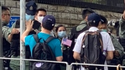 香港市民李先生手持小型的紙製美國國旗,與多名朋友7月4日下午到美國駐港總領事館附近慶祝美國國慶,他們被大批警員截查。(美國之音 湯惠芸拍攝)