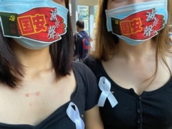 香港市民I小姐及T小姐在口罩上贴上反对港牌国安法的标语,呼吁香港人发挥流动文宣的创意。 (美国之音/汤惠芸)