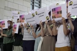 香港获奖记者蔡玉玲的支持者在法庭外举牌支持。(2021年4月22日)