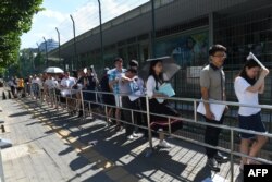 2018年7月26日,人们在北京的美国大使馆外面排队申请签证。