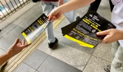 多个民间团体成员派传单,呼吁市民关注入境条例修订影响香港人出入境自由,形容是”闭关锁港” (美国之音/汤惠芸)