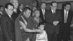 1996年1月12日,中方选择的六岁的11世班禅喇嘛向中国主席江泽民呈现给他的礼品。中国政协主席李瑞环在场。