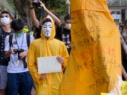 化名V的年青人穿上梁凌杰死前的黄色雨衣,象征与梁凌杰同样为民主自由站出来抗争。 (美国之音/汤惠芸)