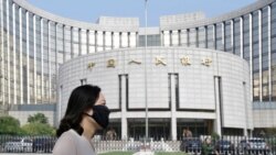 北京的中国人民银行总部大楼前,有人戴口罩走过(2018年9月28日)。