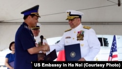 越南海警司令部司令阮光淡少将和美国海岸警卫队首席采购官黑考克少将在檀香山举行的巡逻舰交接仪式上握手。(2017年5月25日)