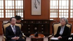 韩国外交部长官康京(右)3月6日召见日本驻韩大使冨田浩司,抗议日本政府针对韩国加强入境管制.