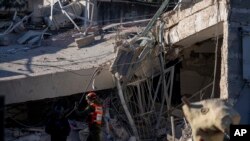 2024年12月19日,以色列特拉维夫郊区拉马特甘的一所学校建筑被胡塞导弹弹片炸倒,一名来自本土指挥军事单位的军官正在检查损坏情况。