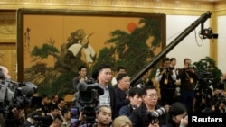 各国记者在等待中国国家主席习近平和其他中共中央政治局常委到达北京人大会堂。(2017年10月25日)