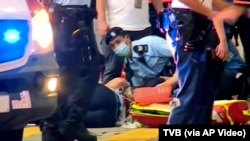 7月1日晚香港一警员在铜锣湾执行任务时遭人刺伤。图为急救人员正在为受伤警员包扎。(照片由香港TVB电视台提供)