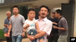 中国劳工权益活跃人士华海峰在江西赣州获得释放后抱着儿子离开(2017年6月28日)
