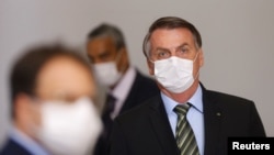 戴着口罩的巴西总统博索纳罗在巴西利亚出席一个宣布采取抗疫措施的新闻发布会。(2020年3月18日)