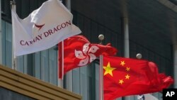 香港港龙航空公司总部大楼外公司旗帜在香港特区旗帜和中国国旗旁飘扬。(2020年10月21日)