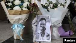 武汉疫情“吹哨人”李文亮医生因感染新冠病毒去世后武汉中心医院大门处的临时祭坛。(2020年2月7日)