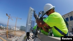 资料图片:美国工人2019年4月在加州安装爱立信的5G设备。