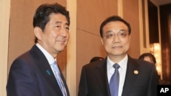 2016年7月15日,日本首相安倍晋三与中国总理李克强在蒙古乌兰巴托举行的亚欧峰会期间举行双边会谈前握手。