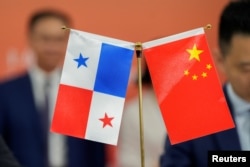 资料照:中国和巴拿马两国官员签署贸易协议期间,中国与巴拿马国旗被摆放在桌子上。(2024年8月26日)