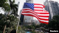 一名男子手持美国国旗在港岛参加反对香港警察对反送中示威者过度使用暴力的游行。(2019年7月28日)