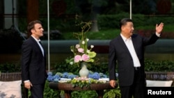中国领导人习近平在广州一个花园里接待到访的法国总统马克龙。(2023年4月7日)