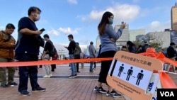 当局有指示牌呼吁排队接受强制病毒检测的香港市民保持社交距离 (美国之音/汤惠芸)