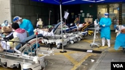 香港第5波新冠病毒疫情引致医疗系统超出负荷,明爱医院急症室外2月18日下午仍有大批等候入院的病人,被安排在户外的病床上 (美国之音/汤惠芸)