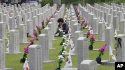2019年6月6日,一名韩国妇女在韩国首尔的国家公墓,在韩战中牺牲的亲戚墓前祈祷。