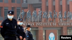 资料照片:2021年2月3日,世界卫生组织团队访问中国湖北省武汉市,安全人员在武汉病毒研究所外值守。(路透社照片)