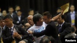 中国全国人大关于李飞在香港介绍北京有关香港政改立场时,梁国雄在现场抗议,被保安人员拖走。(2014年9月1日资料照片)